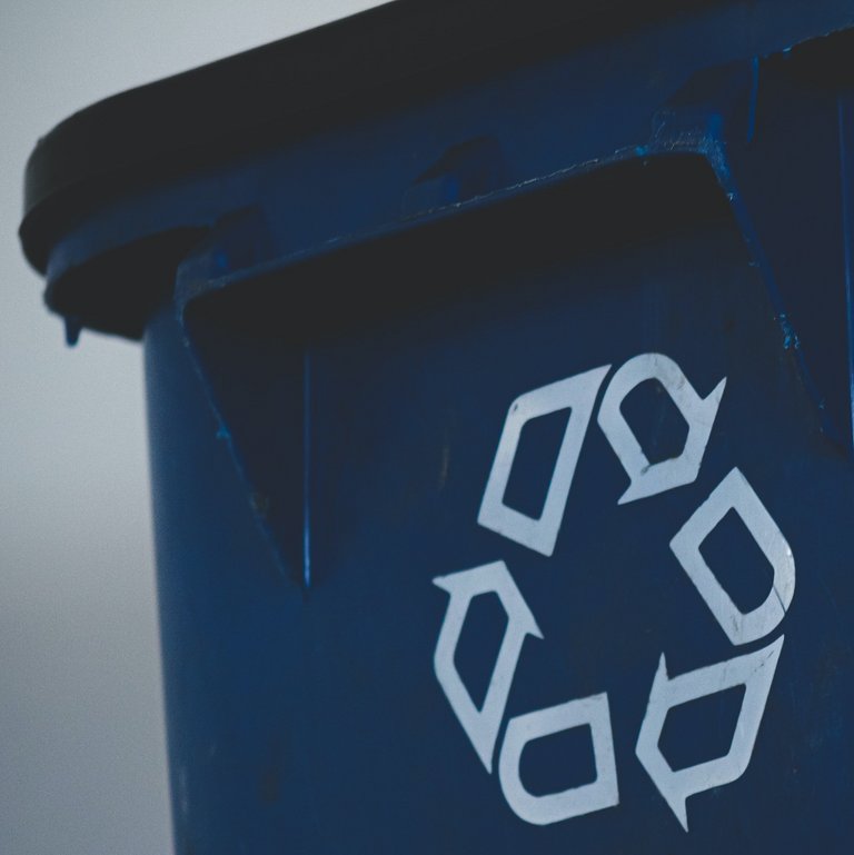 Blauer Abfallkorb mit Recyclingsymbol
