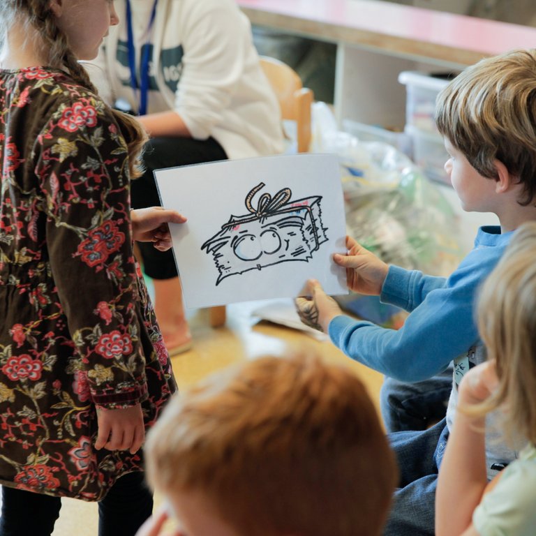 Ein Mädchen zeigt einem Jungen eine Zeichnung