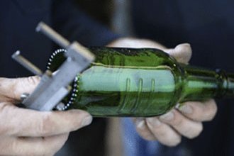 Ein Mann prüft die Glasflasche auf ihre Qualität. 